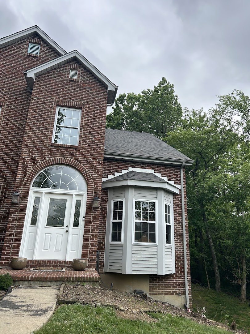 Brick two-storey home with an arched window over the entry and a bay window